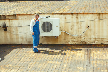 HVAC technician working on a capacitor part for condensing unit. Male worker or repairman in uniform repairing and adjusting conditioning system, diagnosting and looking for technical issues.