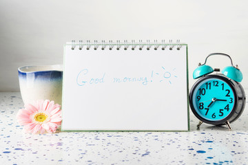 Good morning concept with mug and alarm clock, flower.