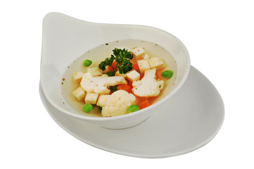 Vegetable soup with cauliflower, potatoes, peas, carrots and parsley on a white isolated background