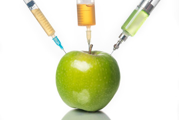 Injection into an apple, GMO concept, pesticides, poisons. White background.