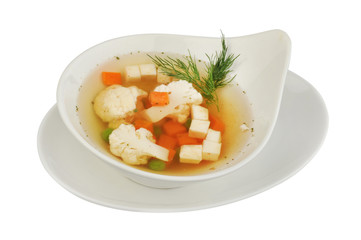 Vegetable soup with cauliflower, potatoes, peas, carrots and dill on a white isolated background