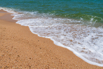 Empty beach with golden sand and azure water