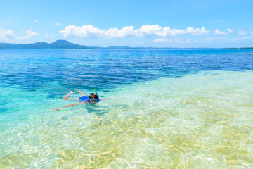 Fototapeta na wymiar Woman snorkeling in caribbean sea, turquoise blue water, tropical island. Indonesia Banyak Islands Sumatra, tourist diving travel destination.