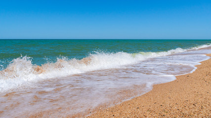 Fototapeta na wymiar Empty beach with golden sand and azure water