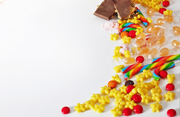 Sweets scattered on the table: chocolate, caramel, Breakfast cereals