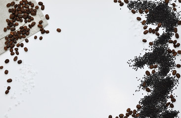 Whole grains of roasted black coffee scattered on a linen towel
