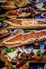 Traditional Turkish cuisine. Pizza, pita, pidesi, sucuk, hummus, kebab, bulgar. Many dishes on the table. Serving dishes in restaurant. Background image. Top view, flat lay