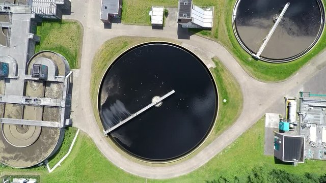 Top down aerial shot of water basins at sewage treatment plant. Sewage treatment removes contaminated wastewater and turns it into environmentally safe clean water.