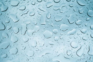 Close up view of water drops falling on glass. Rain running down on window. Rainy season, autumn....