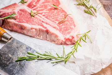 Raw fresh marble T-bone meat on the rustic background. Selective focus. Shallow depth of field.