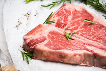 Raw fresh marble T-bone meat on the rustic background. Selective focus. Shallow depth of field.