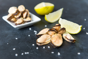 mussels with lime and coarse salt on a black background