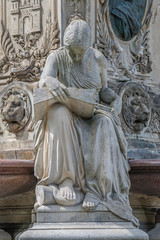 Ancient fountain statue of sensual Italian Renaissance Era woman reading a big book, Magdeburg, Germany