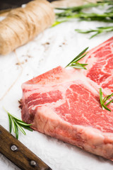 Raw fresh marble T-bone meat on the rustic background. Selective focus. Shallow depth of field.