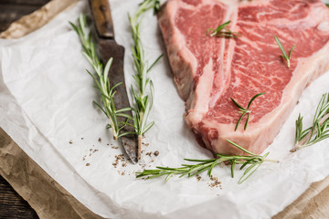 Raw fresh marble T-bone meat on the rustic background. Selective focus. Shallow depth of field.