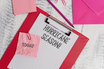 Handwriting text writing Hurricane Season. Conceptual photo time when most tropical cyclones are expected to develop Clipboard sheet pencil crushed note envelope clips notepad wood background