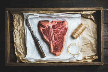 Raw fresh marble T-bone meat on the rustic background. Selective focus. Shallow depth of field.