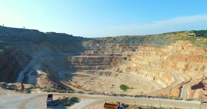 Aerial view of opencast mining quarry with lots of machinery at work - view from above. 