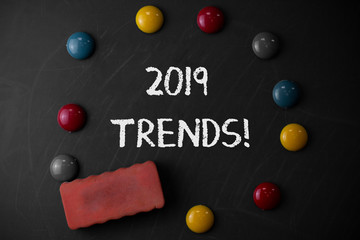 Word writing text 2019 Trends. Business photo showcasing general direction in which something is developing or changing Round Flat shape stones with one eraser stick to old chalk black board