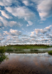 Reflection of clouds in the water. Early morning on the Ugra river