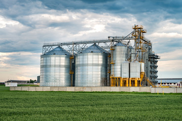 agro-processing plant for processing and silos for drying cleaning and storage of agricultural products, flour, cereals and grain with beautiful clouds © hiv360