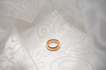 Classic wedding rings lie on the light satin fabric. Wedding rings on the photo for the template under the text. Close-up