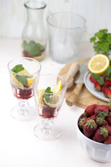 olorful refreshing drinks for summer, cold strawberry lemonade juice in the glasses with ice cubes.