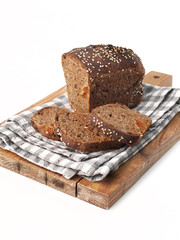 food photography of half a loaf of homemade bread with sliced pieces on a checkered towel side view on a brown board on a white background isolated close up
