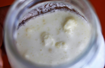 Close-up shot of a glass jar filled with fermenting kefir