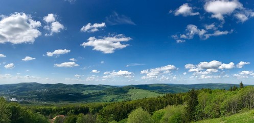 Scenic summer hike to the Wasserkuppe, the highest mountain of the Rhoen (Germany) & its Radom (radar station during cold War) through lush green nature landscape with a bright blue sky & white clouds