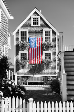 United States flag at suburban neighborhood. Provincetown, Cape Cod, Massachusetts, USA. Black and white image.