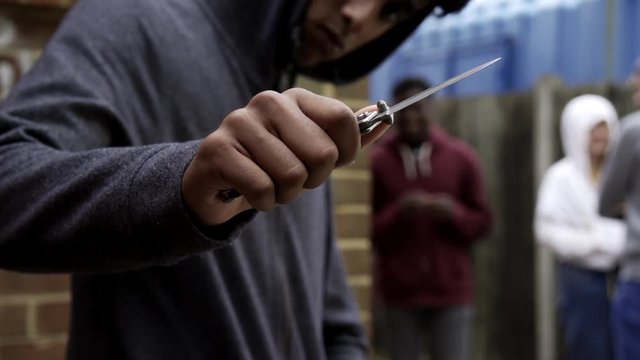  Teenage Boy In Urban Gang Pointing Knife Towards Camera In Threatening Way