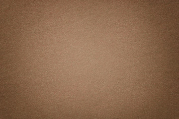 Light brown matt suede fabric closeup. Velvet texture of felt.