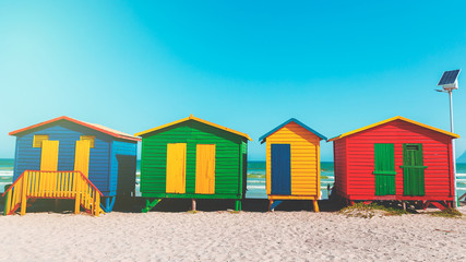 Muizenberg beach with white sand and colorful wooden cabins in Cape Town, South Africa
