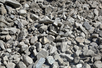 Gray textured surface of a heap of construction pebbles and gravel