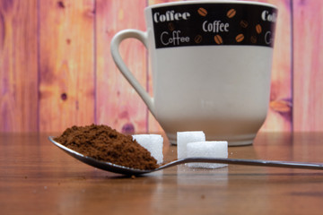 Coffee in a spoon and three pieces of sugar