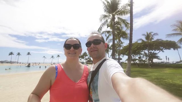 Happy couple taking a selfie at Waikiki beach in Honolulu Hawaii in 4k slow motion  60fps