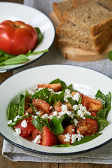 Tomato salad with sorrel and cottage cheese in a white bowl