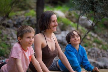 A woman trains with children in the yard.