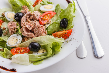 Fresh salad with iceberg lettuce,tomatoes,eggs,canned tuna and olives