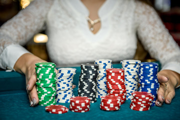 Female hands holding piles of casino chips on table