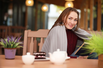 Young girl in cafe sits and drinks tea