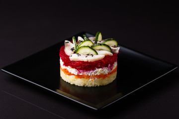 Russian salad herring under fur coat on a dark background
