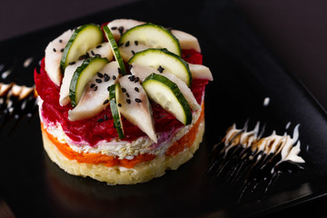 Russian salad herring under fur coat on a dark background