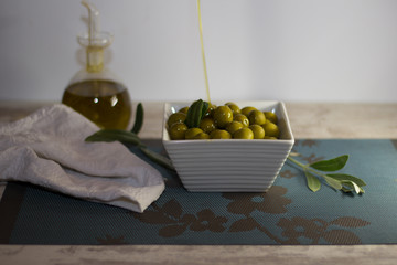 olives in bowl on wood and  oil