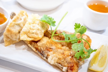 Delicious dim sum, famous cantonese food in asia - Fried fish and dumplings with lemon, sauce and tea in hong kong yumcha restaurant, close up