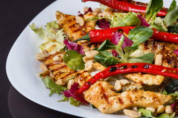 Mexican salad with hot pepper chiken fillet lettuce on plate