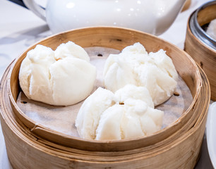 Delicious dim sum, famous cantonese food in asia - Fresh and hot Cha Siu Bao, BBQ pork bun in bamboo steamer in hong kong yumcha restaurant, close up