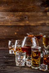 Assortment various hard and strong alcoholic drinks in different glasses: vodka, cognac, tequila, brandy and whiskey, grappa, liqueur, vermouth, tincture, rum, etc. Wooden background copy space