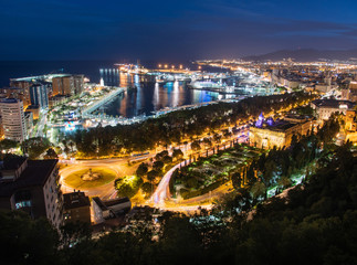Fototapeta premium Cityscape and light trails of cars on highway, aerial view of Malaga, Spain